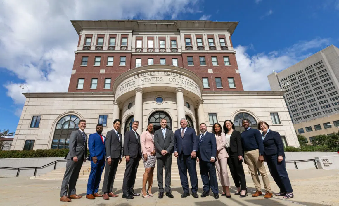 the law firm's lawyers and support staff pose outside the federal courthouse